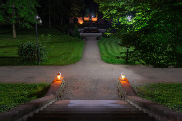 Park w mieście Iłowa w Polsce w nocnej scenerii. Ciemności rozświetlają lampiony ustawione na...