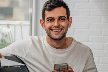 young man using mobile phone at home