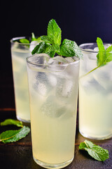 Glasses Limonata Turkish Lemonade with a Mint Garnish: Lemonade with a mint garnish on a wooden table