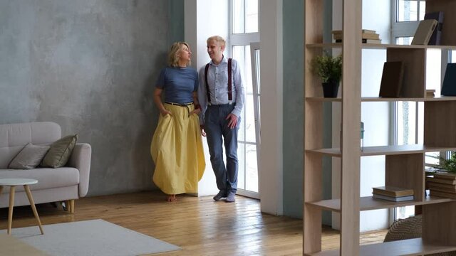 Mature Mother Talking with her Adult Son by the Window in the Living Room at Home. Bonding and Family Reunion, Mothers Day Concept