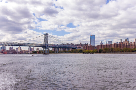 A picture of Williamsburg Bridge in New York City, USA. In the picture one can see the East River and Manhattan skyline