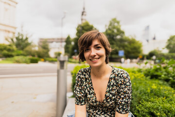 Obraz premium Portrait of an attractive young female sitting and relaxing on a bench in a park