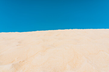 Scenic landscape of yellow sand dunes and blue sky background. High quality photo