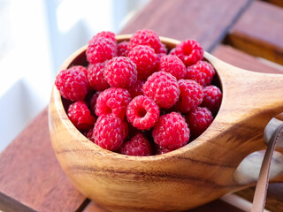 Wooden cup with wild raspberries