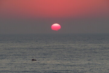 Sunrise over South African coast with boat in the foreground