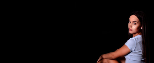 young girl with a pleasant appearance on a black background. place for text. Banner
