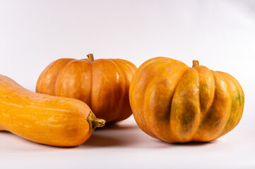 Three whole fresh orange big pumpkin on white background, closeup. Organic agricultural product, ingredients for cooking, healthy food vegan.