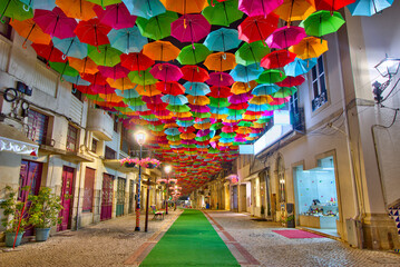 Colorful umbrellas in the street during the Agitágueda street festival in Águeda, Portugal - Powered by Adobe