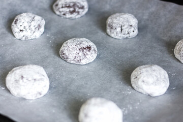 Cookie dough rolled in balls on a parchment paper.