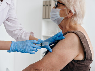 Nurse giving an injection to an elderly woman patient vaccine passport