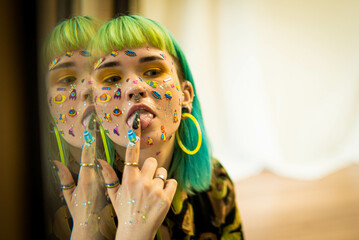 Closeup fashion portrait young pretty beautiful girl with green and blue hair. Beautiful fashion girl with luxury professional makeup and funny emoji stickers glued on the face. Young woman - obrazy, fototapety, plakaty