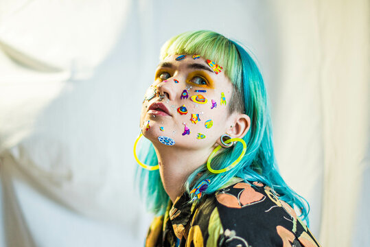 Closeup Fashion Portrait Young Pretty Beautiful Girl With Green And Blue Hair. Beautiful Fashion Girl With Luxury Professional Makeup And Funny Emoji Stickers Glued On The Face. Young Woman