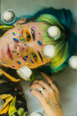 Closeup fashion portrait young pretty beautiful girl with green and blue hair. Beautiful fashion girl with luxury professional makeup and funny emoji stickers glued on the face. Young woman