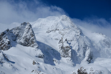 Fototapeta na wymiar Snowy peak of Chegettau-chana mountain. Main Caucasian ridge, Adyr-su gorge.