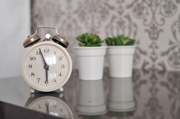 white alarm clock in bedroom at home in the moning,time to wake up, time is money