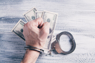 handcuffed at the table with money