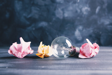 crumpled papers and a light bulb on the table