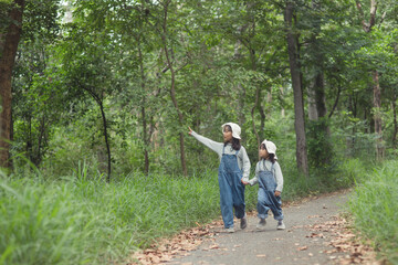 Children are heading to the family campsite in the forest Walk along the tourist route. Camping road. Family travel vacation concept.