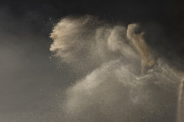 Sand being spun and thrown in the air with dust