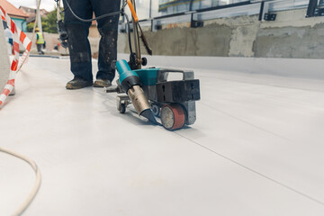 Worker welding pvc  membrane by heater with welder machine