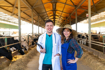 Portrait of farmer and vet standing in barn on dairy farm