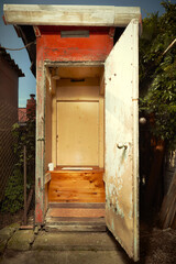 Open door of wooden toilet latrine on summer cottage