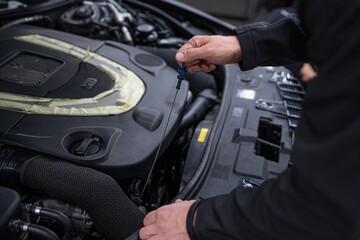Fototapeta na wymiar Car mechanic checking oil level in car service