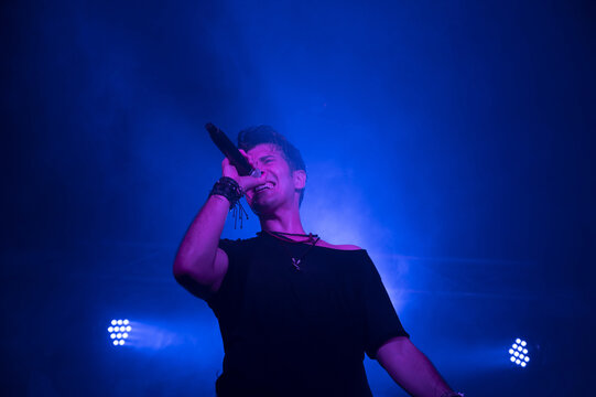 Young energetic singer performing during a concert in a club