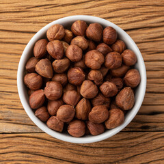 Hazelnuts in a bowl over wooden table