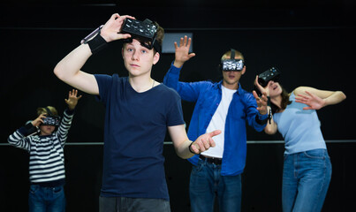 Portrait of a teenage boy who took off his virtual reality glasses, who poses against the background of a family