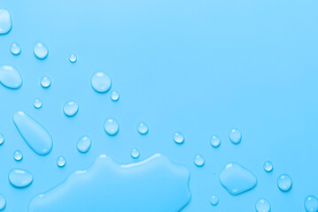 Splash of Water and drops on a pastel blue background. Water texture close up. Backdrop glass covered with drops of water. Water bubbles