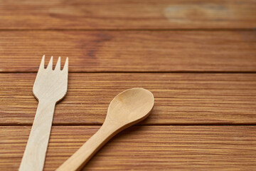 Ecological cutlery made of bamboo on wooden board. Environmental conservation concept