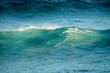 waves crashing in the ocean with the sun light on them