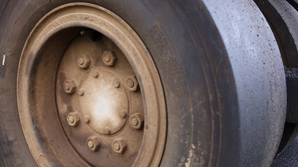 Close up nuts and old wheel hubs. Dirty road roller tires with copy space. Selective focus
