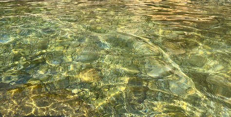 Clear sea water surface. Beautiful summer seascape. Amazing emerald green watercolor . Pebble beach. Sea smooth stones. Calm ocean water. Zen. Relax. Nature. Paradise lagoon.  Green water background.