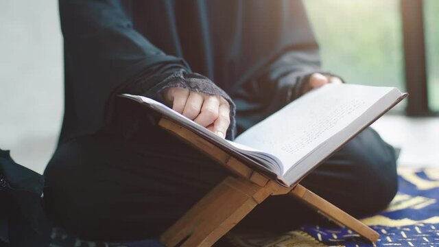 Portrait of an Asian Muslim women in a daily prayer at home reciting Surah al-Fatiha passage of the Qur'an in a single act of Sujud called a Sajdah or prostration