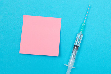 Vaccination, Immunology or Revaccination Concept - A Medical Disposable Syringe Lying on Blue Table...