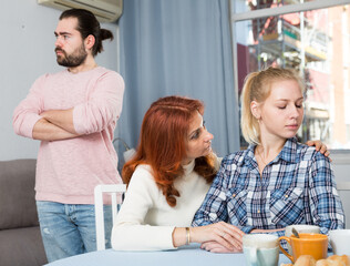Portrait of woman having serious quarrel with adult children in home interior