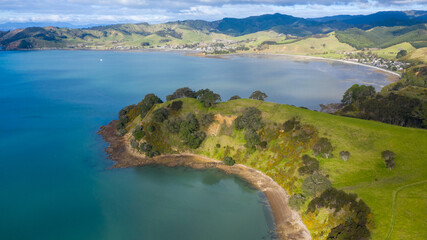 Obraz premium Aerial View of Waitawa Regional Park, Beach, Pier, Deck Green Trees and Cliff in New Zealand - Auckland Area