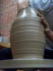 The hand of a man who makes pottery out of clay.