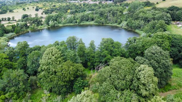 Aerial view of bosmare lake needham market england. Drone fly above the lake with Green Meadows field