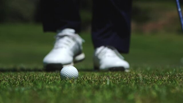 Placing golf ball on tee carefully for swing