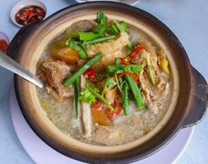 Popular Chinese cuisine. Fish Head Noodle Soup. Deep fried grouper fish head, thick rice noodle, creamy sourish broth with pickled mustard vegetable, tomatoes, sour plum and evaporated milk