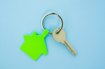 key chain with house symbol and keys on blue background,Real estate concept