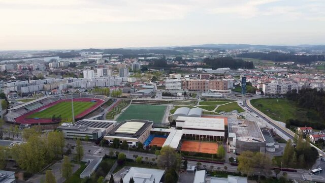 Aerial view  passes through the city and stadium of Maia in Portugal at evening. Establishing the concept of building,vila,stadium,rods,nature, neighborhood, suburb,Real estate, drone shots, sunset.