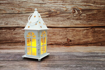 Obraz na płótnie Canvas White Lantern decorative with candles with space copy on wooden background