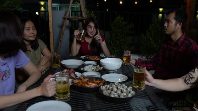 Group of asian people dinning party in the garden of home on holiday,Summer evening garden party celebration with Friends