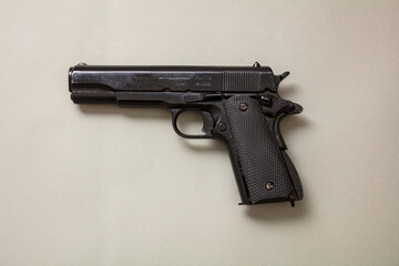 Pistol gun 9mm on gray color background. Black metal weapon side view
