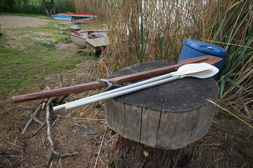 Wooden, old paddles from a small boat on the shore of the lake 