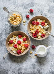 Delicious breakfast - cottage cheese with Greek yogurt, raspberries and sugar cookies crumbs on a gray background, top view